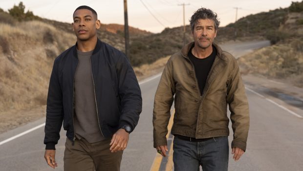 Aaron Pierre and Kyle Chandler walking on the road toward the camera - Lanterns First Look Image - Courtesy of HBO